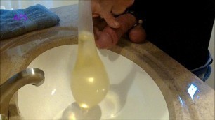 Crossdresser pissing and filling a magnum Condom